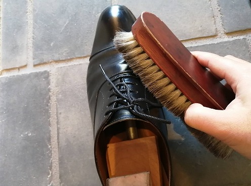 革靴にブラシをかける